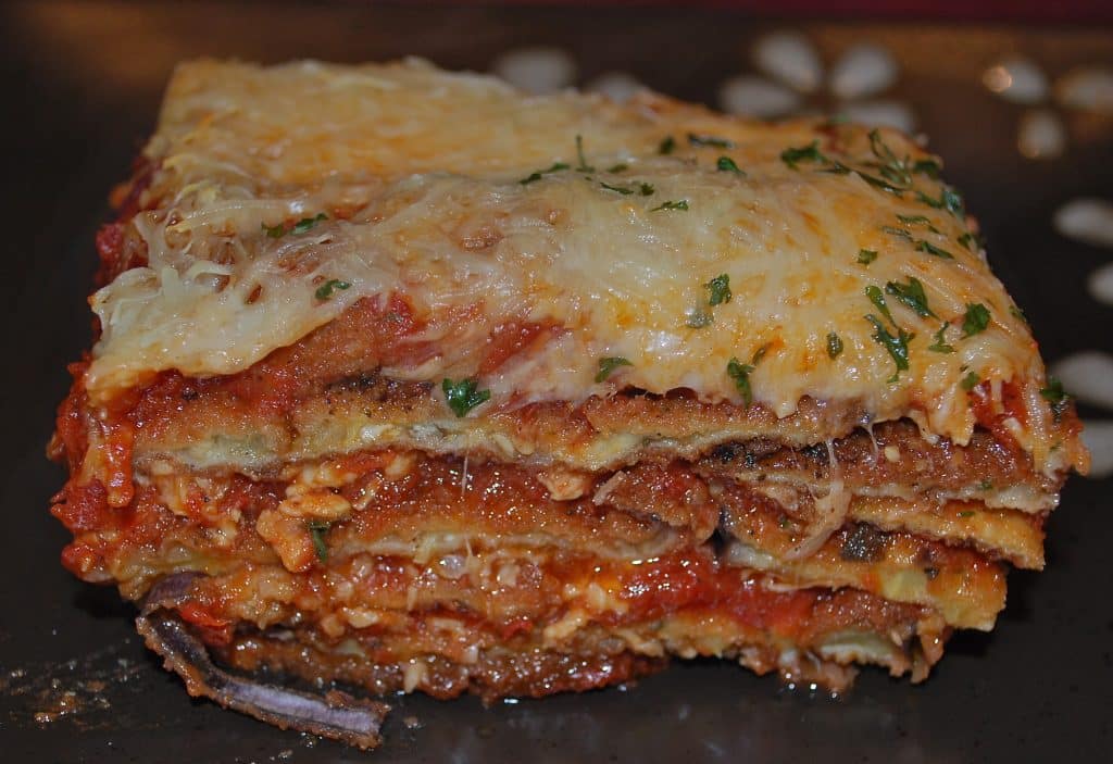 A close up of a slice eggplant parmesan on a plate. 