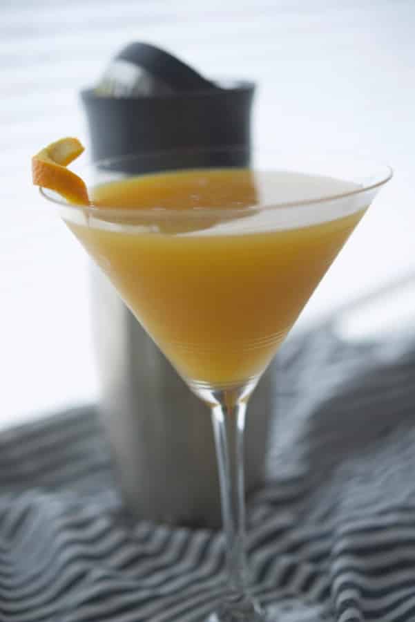 A glass of orange juice, with Coconut martini
