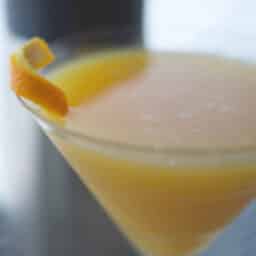 A close up of a glass of orange juice, with Coconut martini