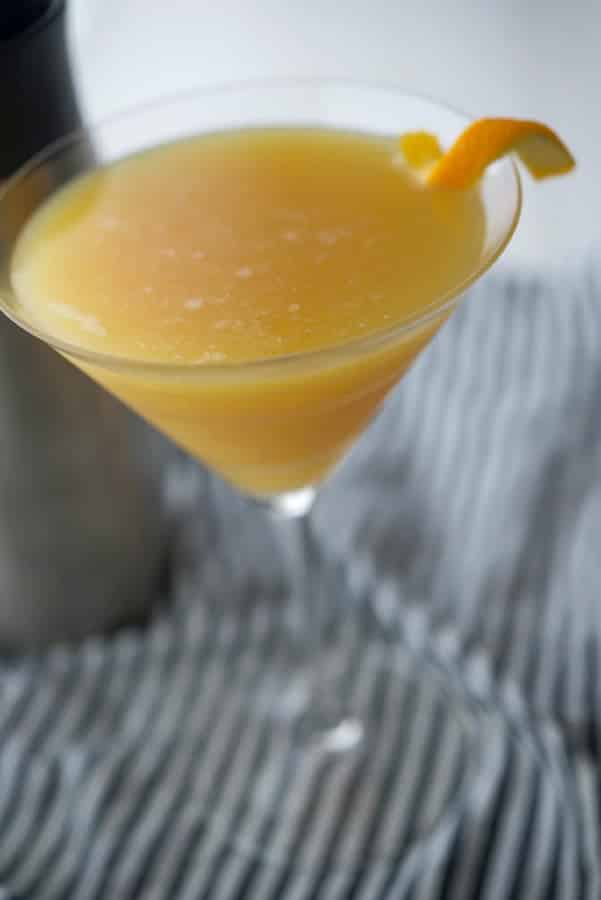 A glass of orange juice, with Coconut martini