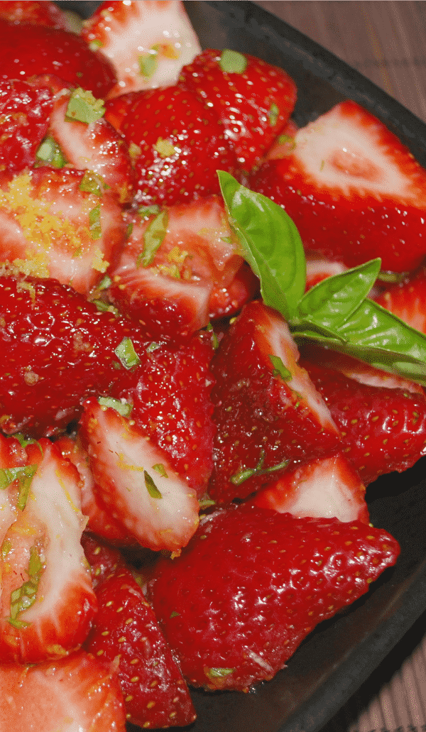 sliced strawberries with grated lemon and basil