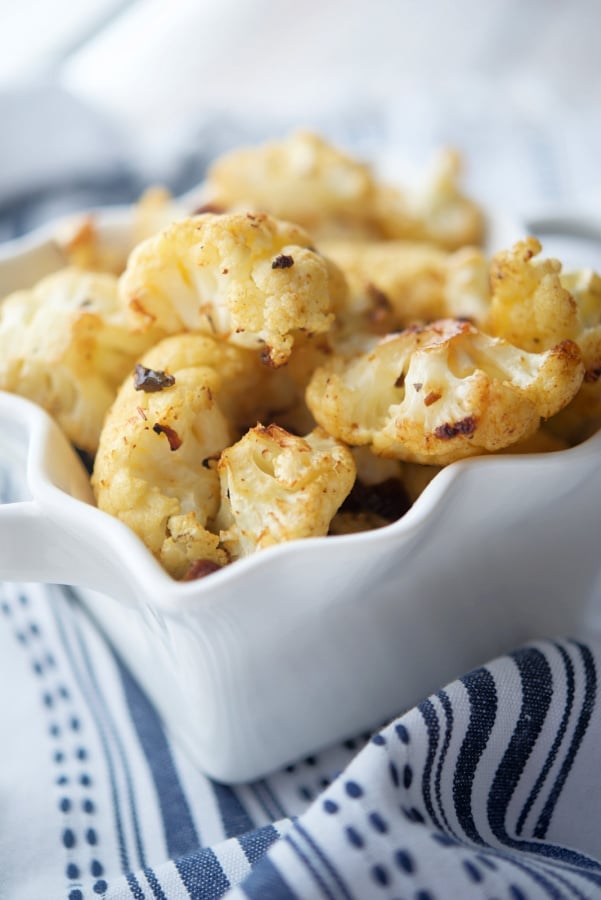 A close up of sun dried tomato cauliflower in a white dish.