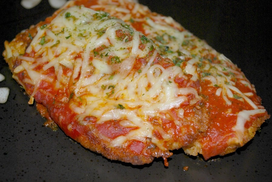 A close up of chicken cutlets with tomato sauce and mozzarella cheese. 