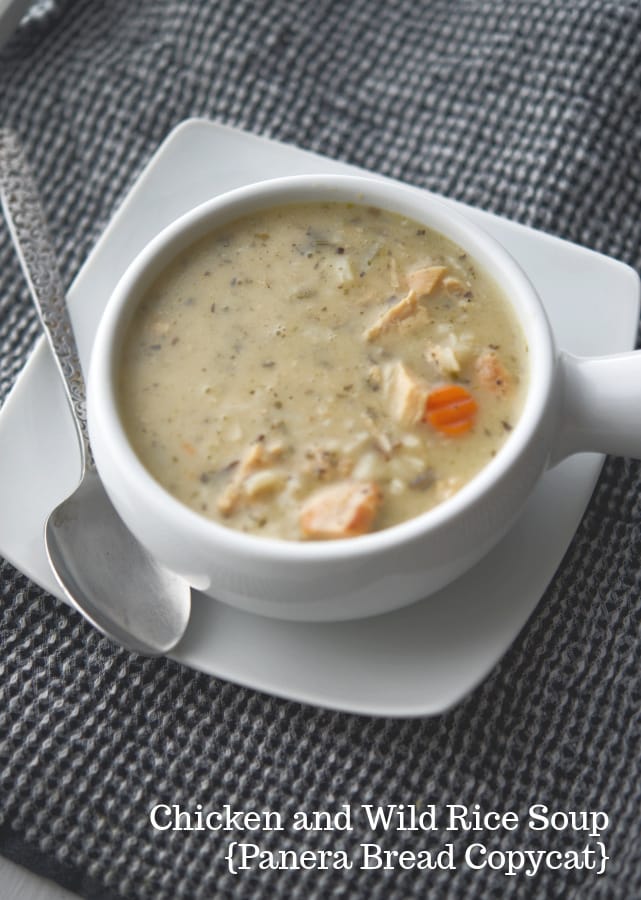 Panera copycat Chicken and Wild Rice Soup in a white soup crock with a spoon. 