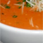 A bowl of soup, with Tomato and Basil