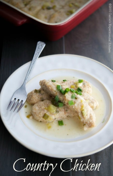 A close up of Country Chicken on a plate with a fork. 