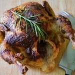 A close up of Balsamic Roasted Chicken on a wooden cutting board.