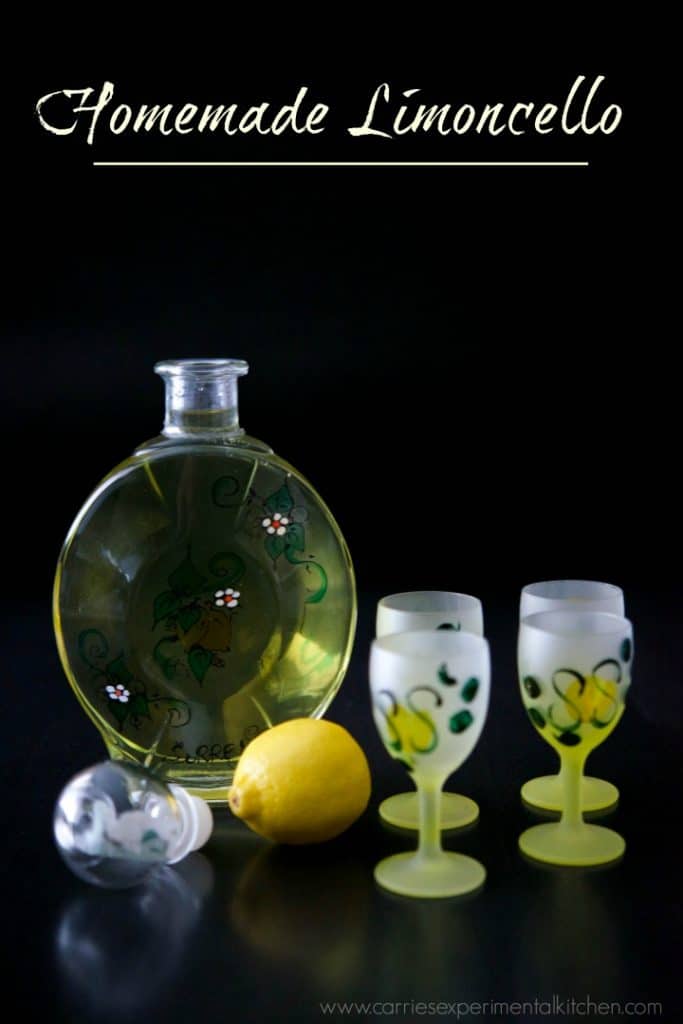 Limoncello in a bottle with shot glasses and a lemon.