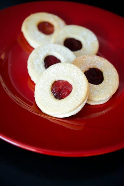 Raspberry Linzer Tarts are one of our favorite holiday treats made with two buttery cookies with tart raspberry preserves spread on the inside.