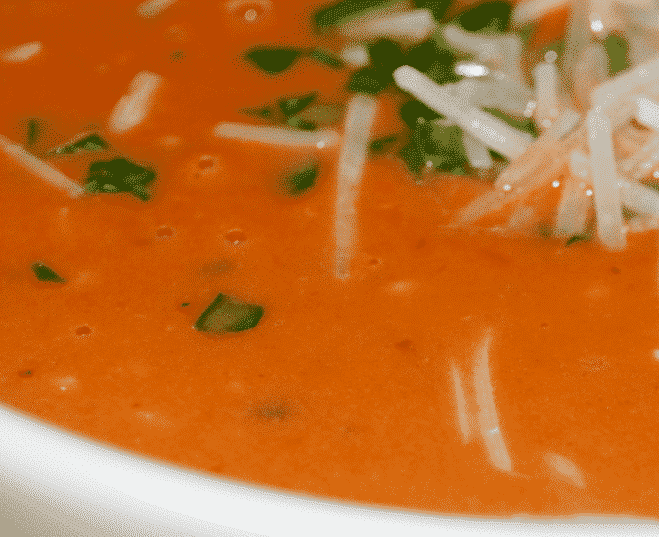 A bowl of soup, with Basil and Tomato