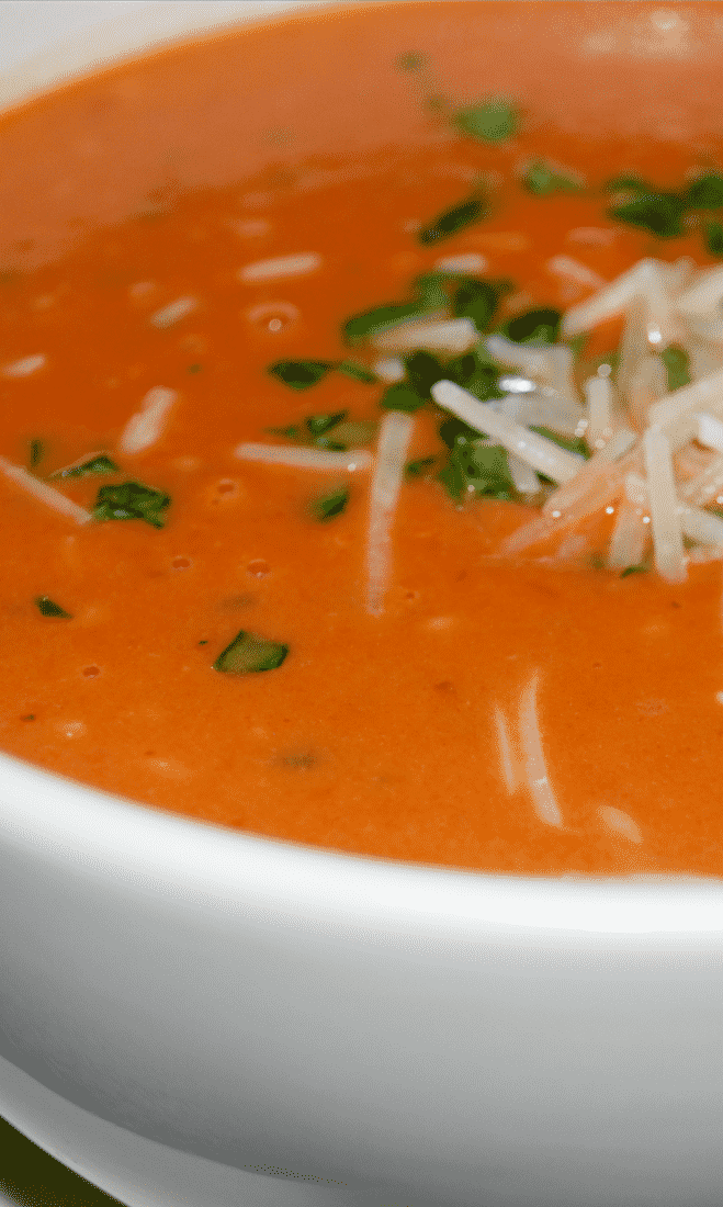 A bowl of soup, with Basil and Tomato