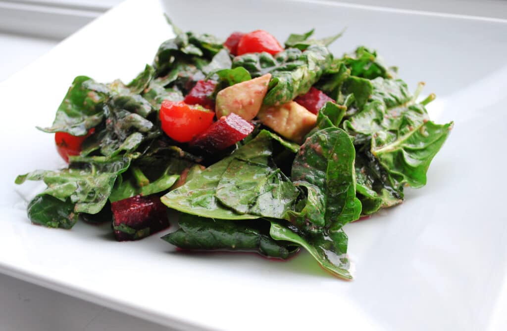 Spinach salad in a white plate.