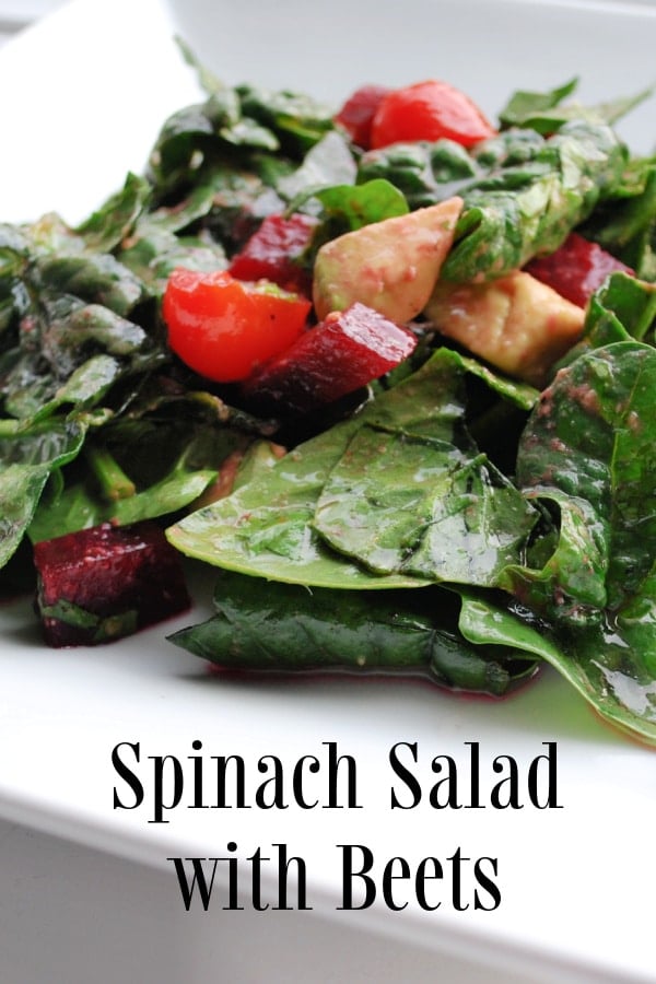 A plate of spinach salad with beets.