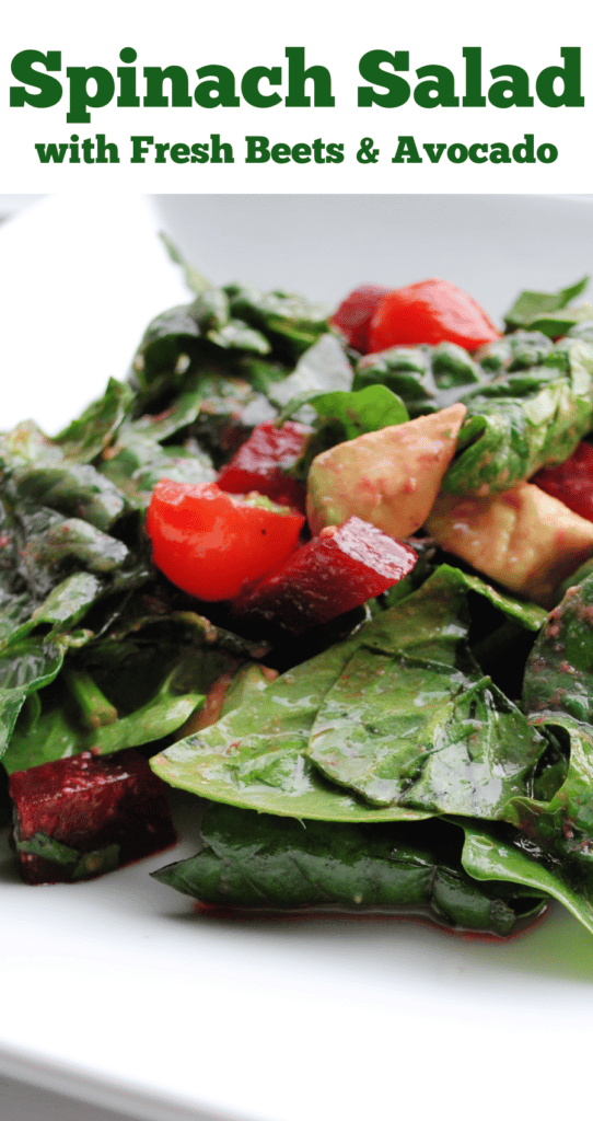 A close up of spinach salad on a white plate with description.