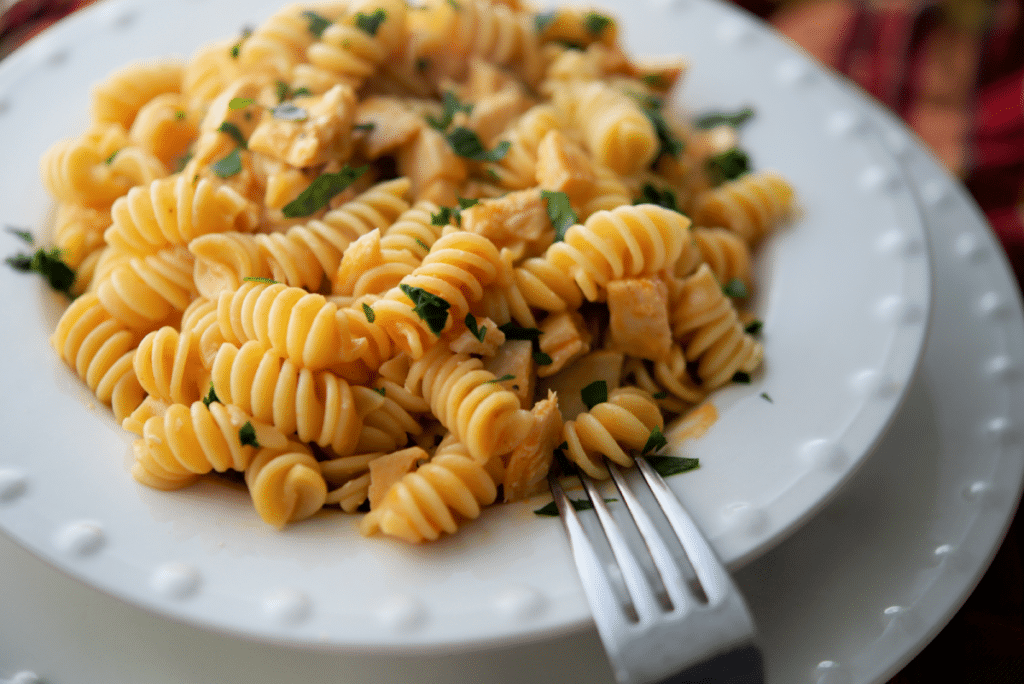 a close up of buffalo chicken pasta in a white bowl