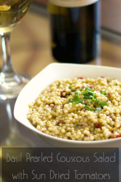 A plate of food and a glass of wine, with Salad and Couscous