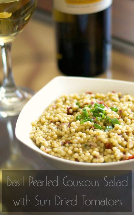 A plate of food and a glass of wine, with Salad and Couscous