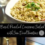 A plate of food and a glass of wine, with Salad and Couscous