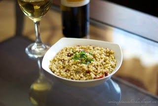 A bowl of food and a glass of wine, with Couscous