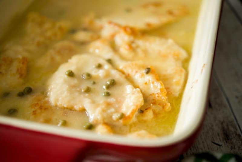 Chicken Piccata in a red baking dish.