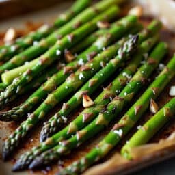a close up of roasted asparagus on a sheet pan