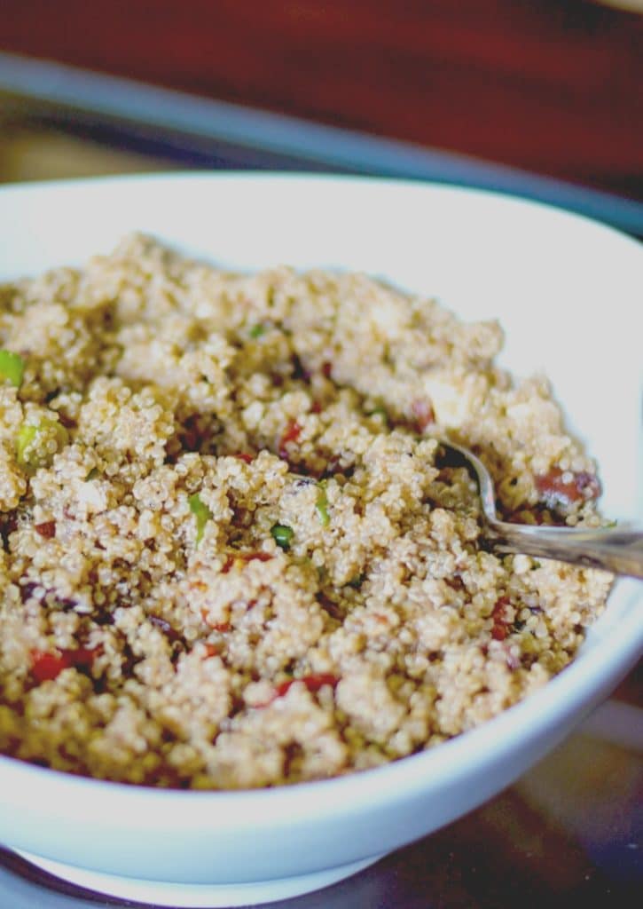 A bowl of food on a plate, with Quinoa salad