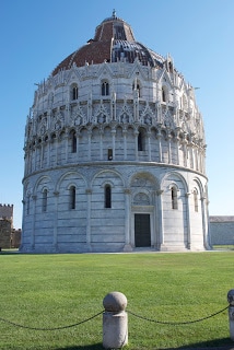 A large stone building with a grassy field