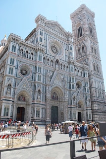 A group of people in front of a church with Florence Cathedral in the background