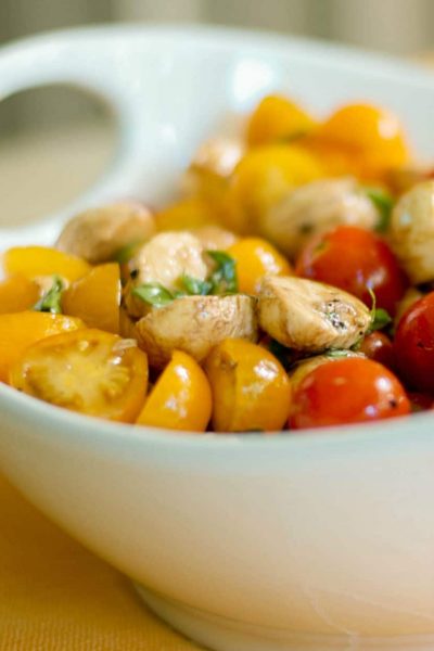 Caprese Salad with yellow and red tomatoes in a bowl.