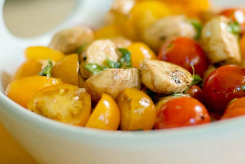 Caprese Salad with yellow and red tomatoes in a bowl.