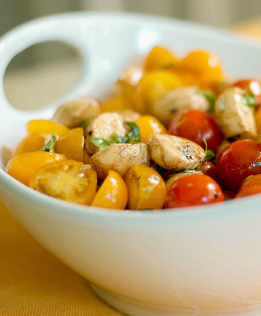 Caprese Salad with yellow and red tomatoes in a bowl. 