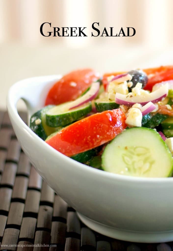Greek tomato cucumber salad in a white bowl.