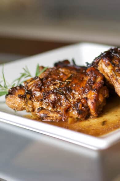 A close up of a plate of balsamic chicken thighs.