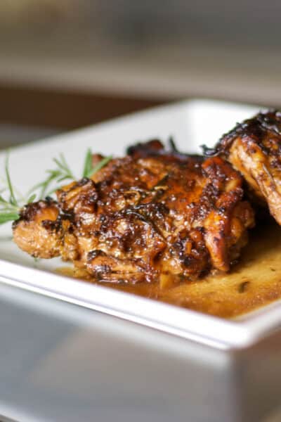 A close up of a plate of balsamic chicken thighs.