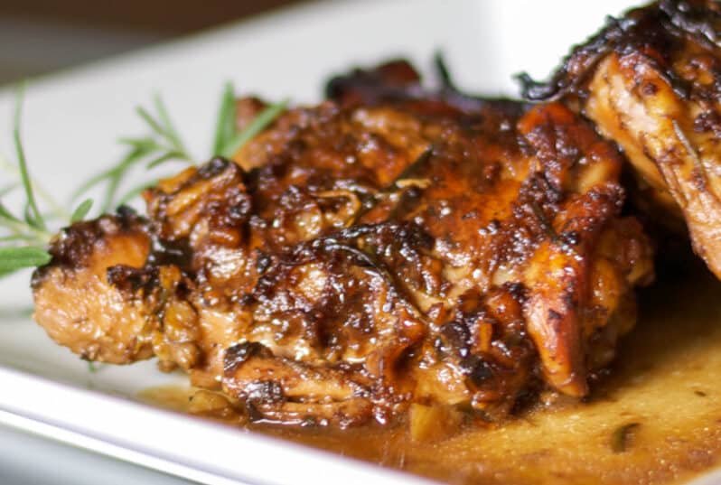 A close up of a plate of balsamic chicken thighs.