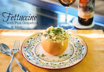 A plate of food on a table, with Fettuccine and Grapefruit