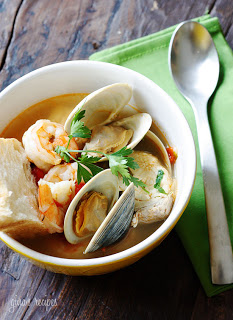 A bowl of food on a plate, with Seafood and Soup