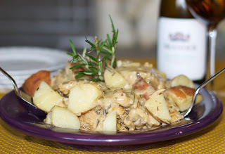 A plate of food on a table, with Chicken, Potato and Wine