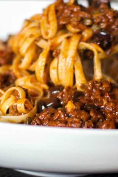 Fettuccine with Sausage Puttanesca Sauce made with sweet Italian sausage, Kalamata olives, capers, garlic, plum tomatoes and red wine. 