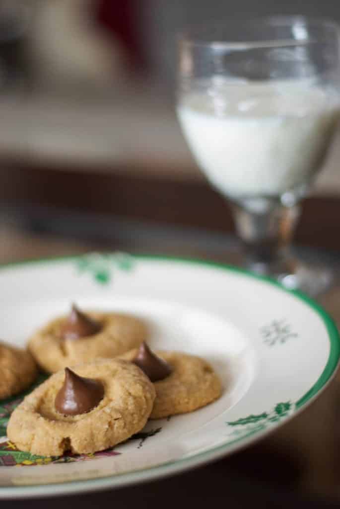 A plate of Peanut Butter Blossoms with milk 