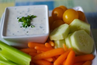 A tray of food on a plate, with Yogurt and Ranch Dressing