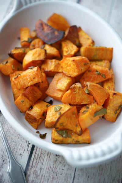 Roasted Sweet Potatoes with Sage in a white baking dish