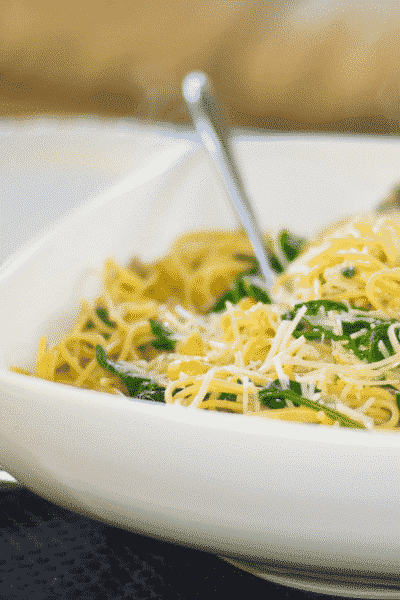 Whole Grain Spaghetti with Sauteéd Chick Peas and Spinach in a white pasta bowl.