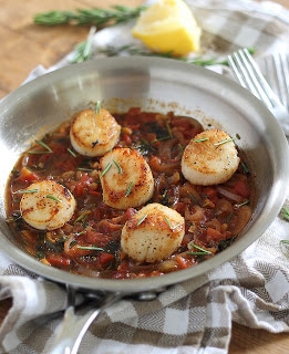 A bowl of food on a plate, with Seafood and Lemon