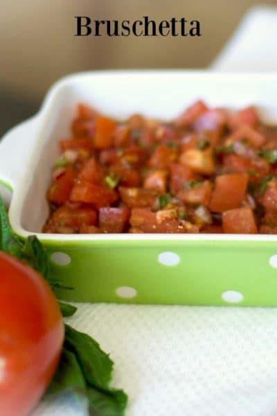 A close up of bruschetta in a green and white dish.