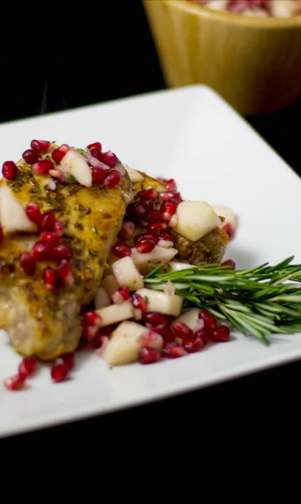 A plate of food on a table, with Pork and Pomegranate salsa