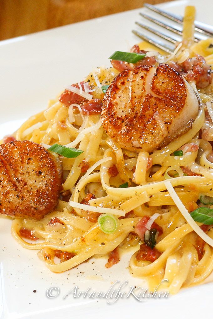 A plate of pasta with meat and vegetables, with Scallops and Seafood