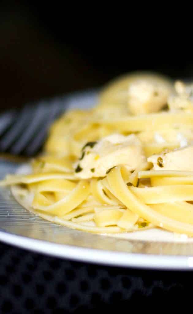 A close up of Chicken Scampi over Fettuccine on a plate