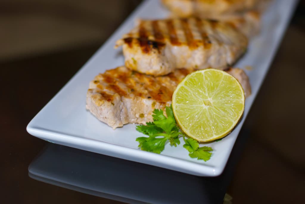 A plate of Cilantro Lime grilled Pork chops on a table