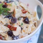 Grilled Chicken Pasta Salad with Kalamata Olives, Capers and Sun Dried Tomatoes in white bowl